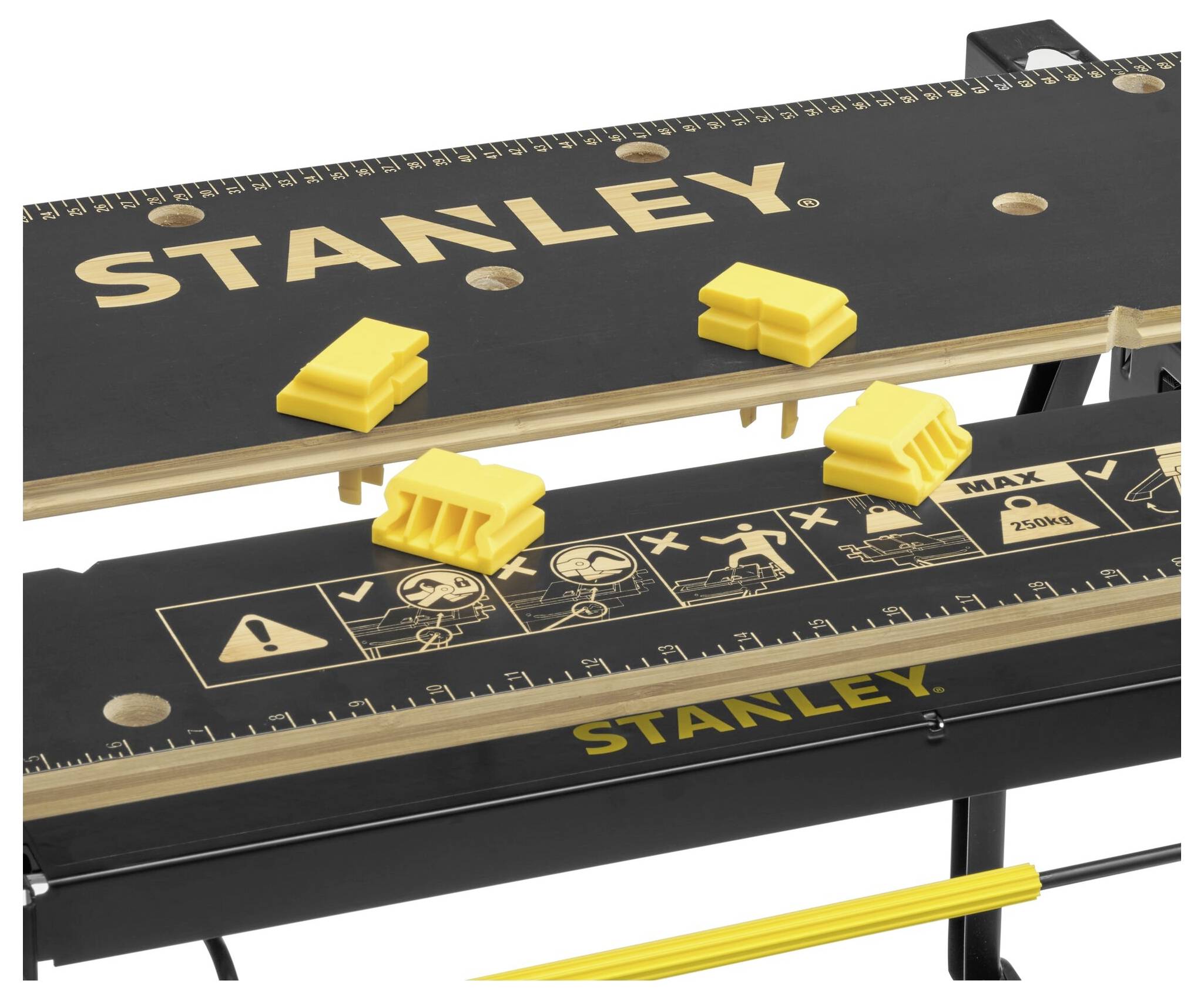 Petite table de travail pliante de Stanley avec graduations sur règle et pinces de serrage jaunes, idéale pour les travaux de bricolage.