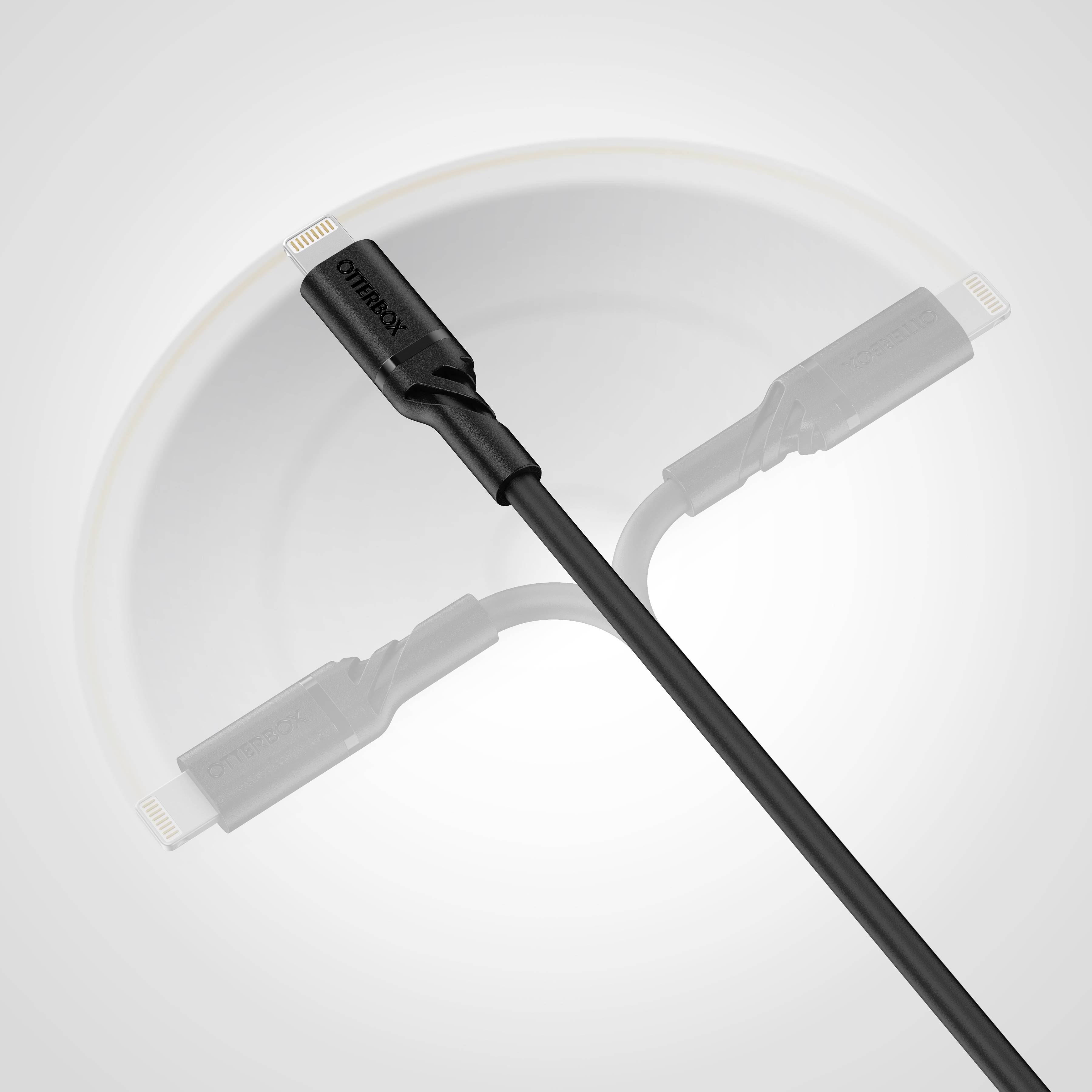 Un câble de charge noir avec une prise sur un fond gris. La prise est orientée vers le haut. Le câble est légèrement courbé.