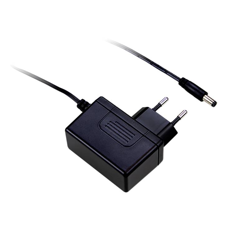 Un adaptateur secteur noir avec une fiche européenne et un câble. Il a une forme rectangulaire et sert à alimenter des appareils électriques.