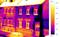 Image thermographique d'une maison montrant les pertes de chaleur au niveau des fenêtres et des portes. L'échelle de couleurs à droite visualise la température de 10 à 13 °C.