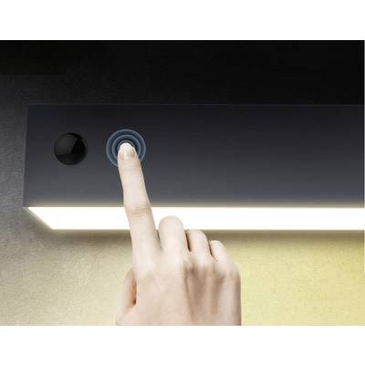 Une main appuie sur un bouton-capteur d'une lampe rectangulaire lumineuse pour l'activer ou la désactiver.