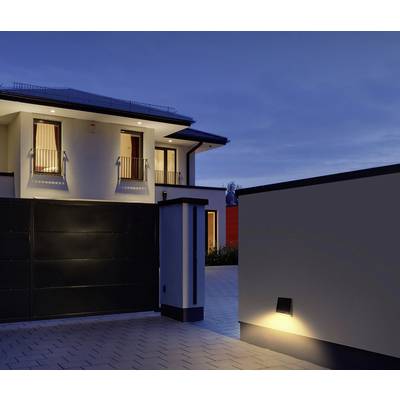 Maison à deux étages au crépuscule, fenêtres éclairées et portail d'entrée. Architecture moderne aux lignes épurées.