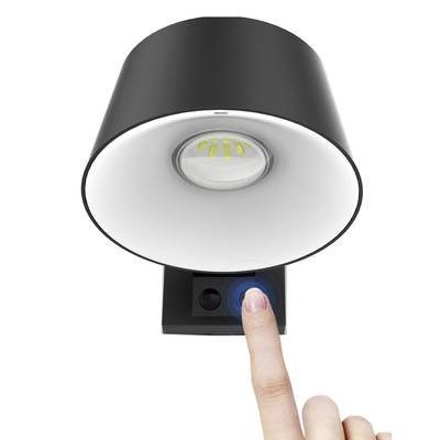 Une lampe de table noire avec une commande par capteur tactile intégrée pour ajuster la luminosité est activée par un doigt.