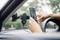 Une personne fixe un smartphone sur un support de téléphone dans une voiture. Le support est installé sur le pare-brise.