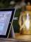 Une tablette avec une clé USB branchée est posée sur une table. En arrière-plan, on peut voir une lanterne illuminée.