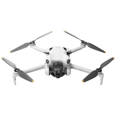 Drone blanche à quatre rotors en vol, avec un module caméra visible à l'avant.