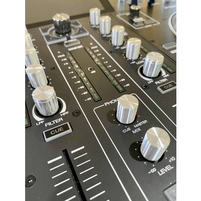 Gros plan sur une console de mixage DJ avec plusieurs boutons rotatifs, curseurs et touches servant à contrôler les paramètres audio.