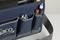 Un sac à outils bleu marine avec plusieurs poches extérieures. Dans les poches se trouvent une clé à molette, un stylo noir et un stylo rouge.