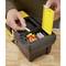 Une personne trie des chevilles dans une boîte à outils noire avec un couvercle jaune. Les chevilles sont grises et rouges.