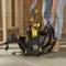 Une personne se tient sur un chantier et tient une visseuse sans fil. À côté d'elle, un sac à outils ouvert contenant divers outils est posé.