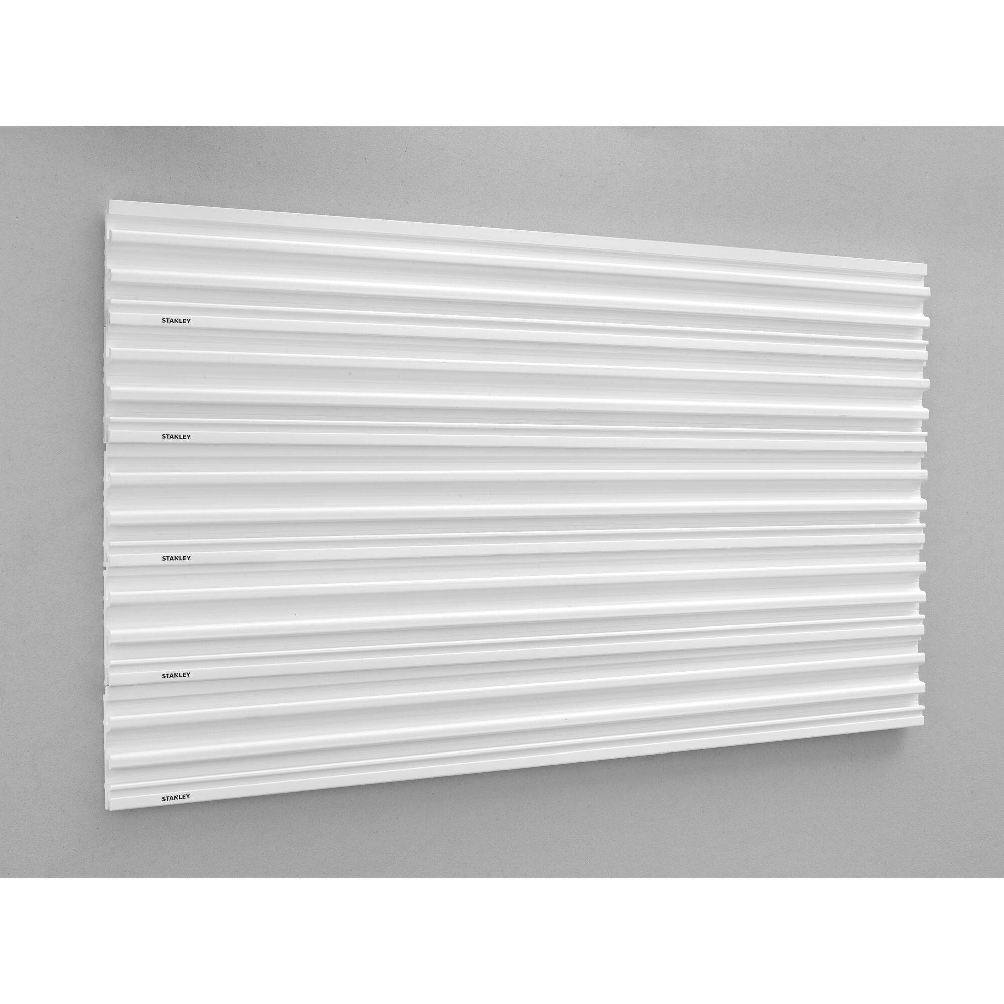 Des panneaux textiles blancs sur un mur gris, avec un motif de rayures horizontales, créent un look moderne et structuré.