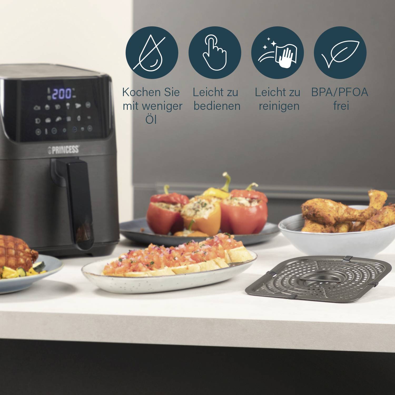 Friteuse à air sur un comptoir de cuisine, entourée d'assiettes de finger food et de légumes. Des icônes illustrent les avantages : moins d'huile, facile à nettoyer.