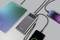 Plusieurs appareils électroniques, dont une tablette et des smartphones, sont connectés à une batterie externe qui les charge.