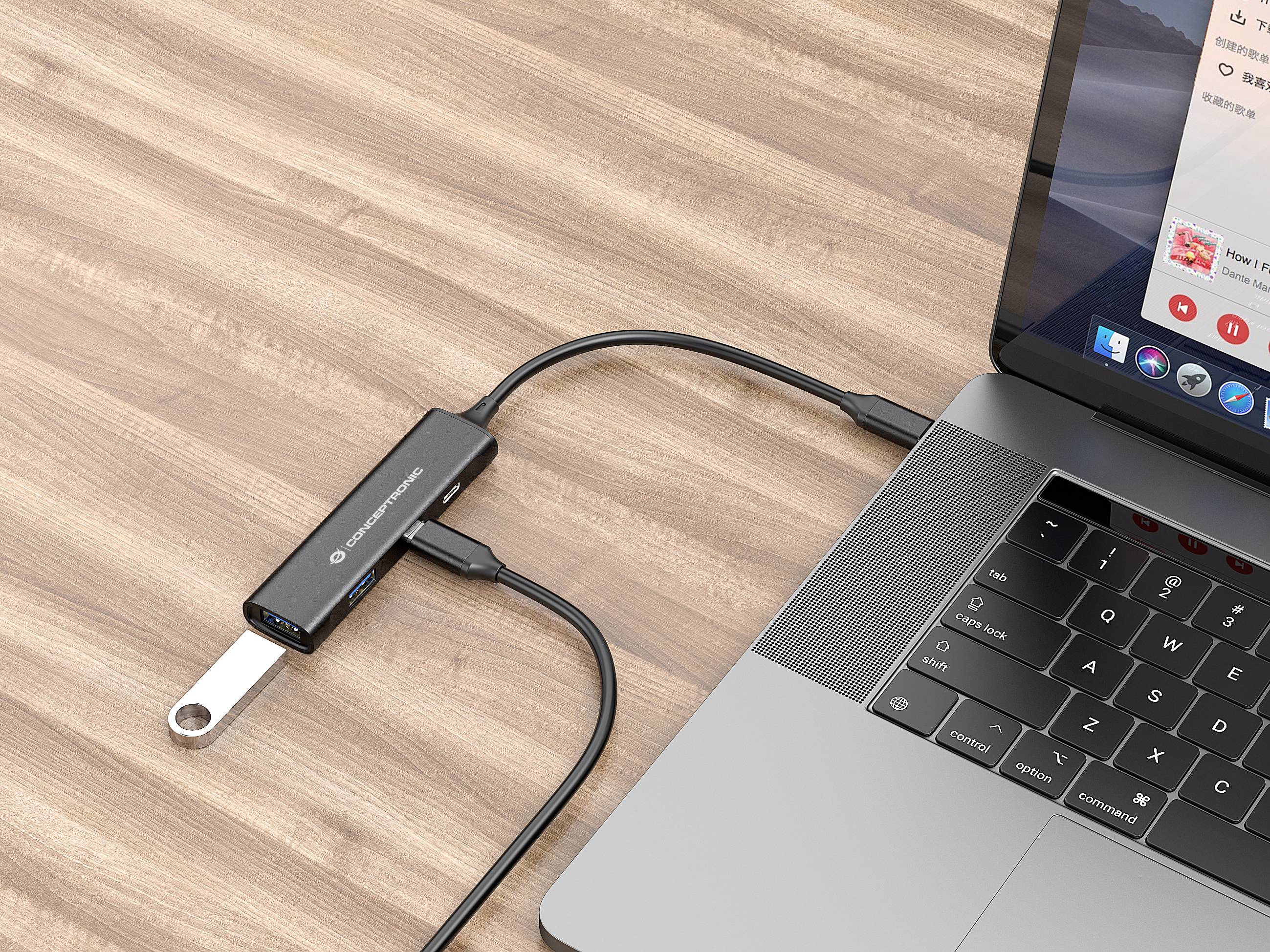 Un ordinateur portable est connecté à une clé USB via un hub USB-C, posé sur une table en bois.