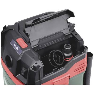 Aspirateur avec compartiment ouvert montrant un rangement intégré pour accessoires à l'intérieur, flexible et embout visibles, marque 'metabo' reconnaissable.