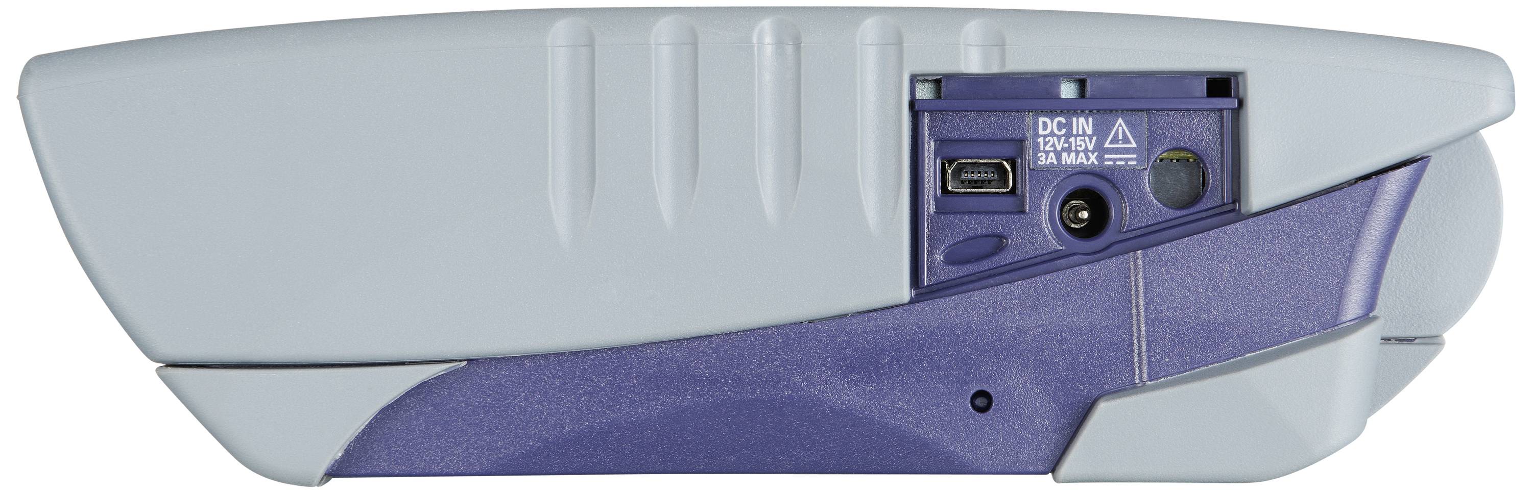 Un appareil électronique gris de forme rectangulaire, photographié de côté. Il présente des ports pour l'entrée DC, un port USB et une prise audio.