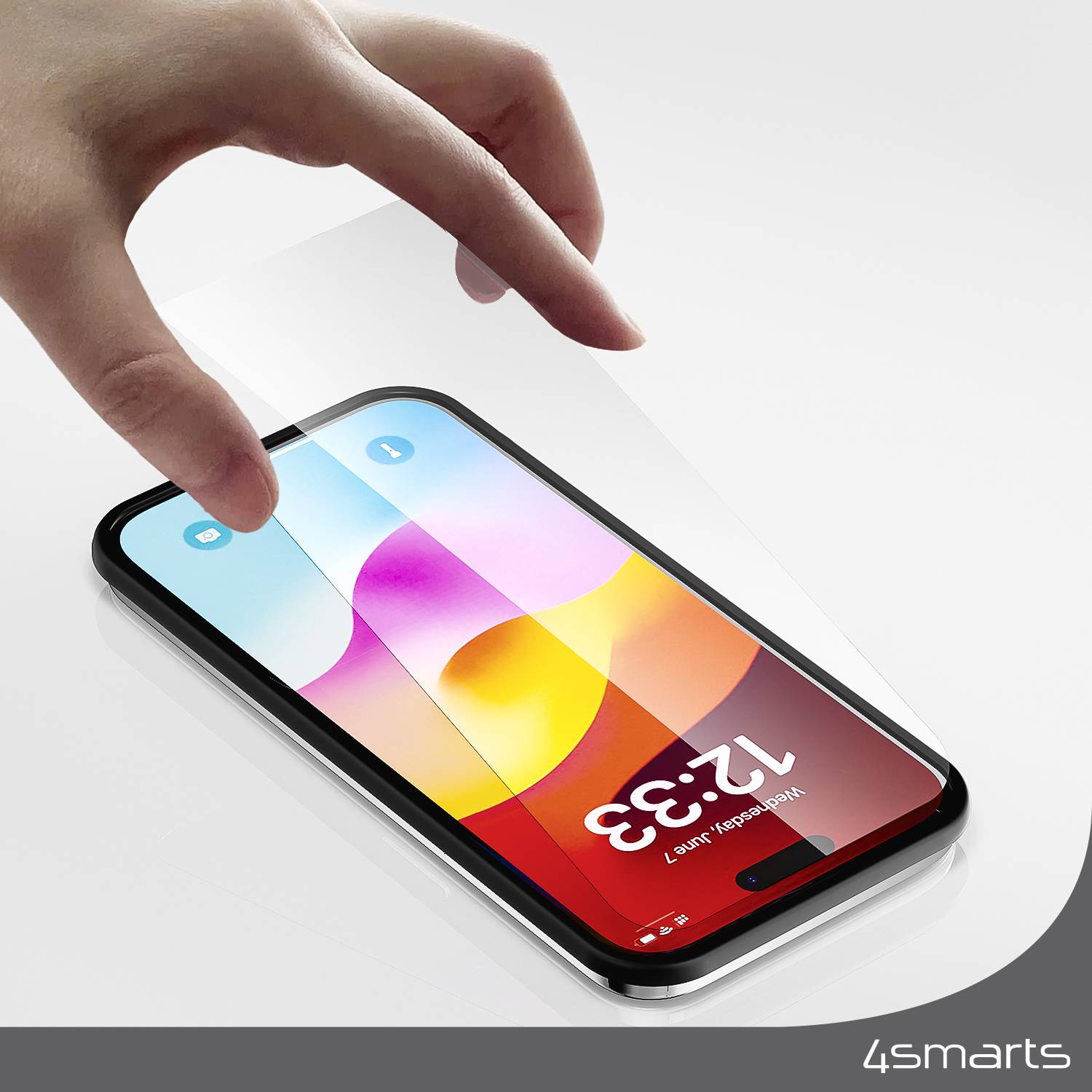 Une main touche un smartphone posé sur une table, l'écran affiche l'heure '12:33' sur un fond coloré.