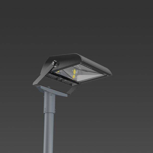 Un lampadaire moderne avec un design rectangulaire à LED sur un poteau en métal gris devant un ciel sombre.