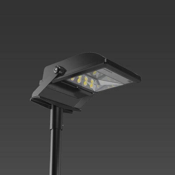 Un lampadaire moderne noir avec des luminaires LED, monté sur un mât noir, sur un fond sombre.