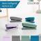 Trois agrafeuses de couleurs différentes sur une table devant un cadre photo et une plante : Violet, Gris, Turquoise. Texte sur l'image : 'Mon agrafeuse - Novus B2'.
