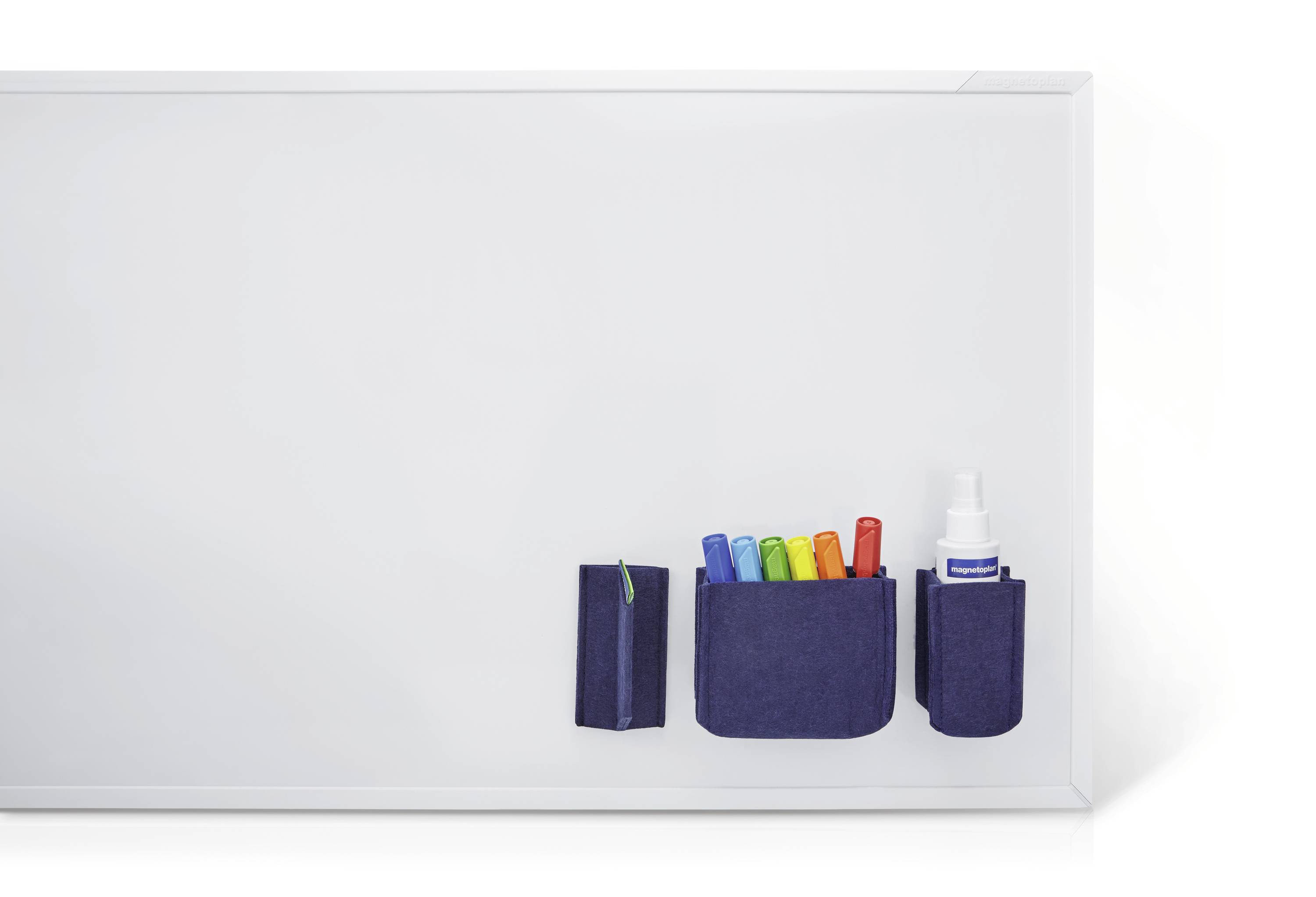 Un tableau blanc vierge avec un support pour marqueurs, rempli de marqueurs colorés, et un flacon de produit de nettoyage sur le côté droit.
