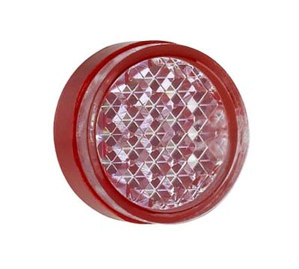 Feu arrière rond rouge avec un motif réfléchissant en forme de diamant au centre.