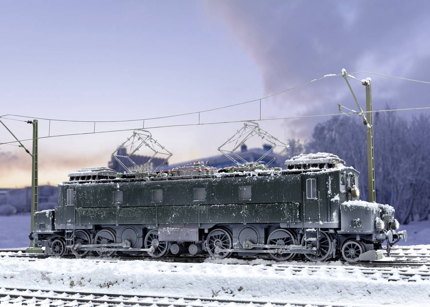 Une locomotive verte sur des rails enneigés, entourée d'un paysage enneigé et d'un ciel nuageux en arrière-plan.