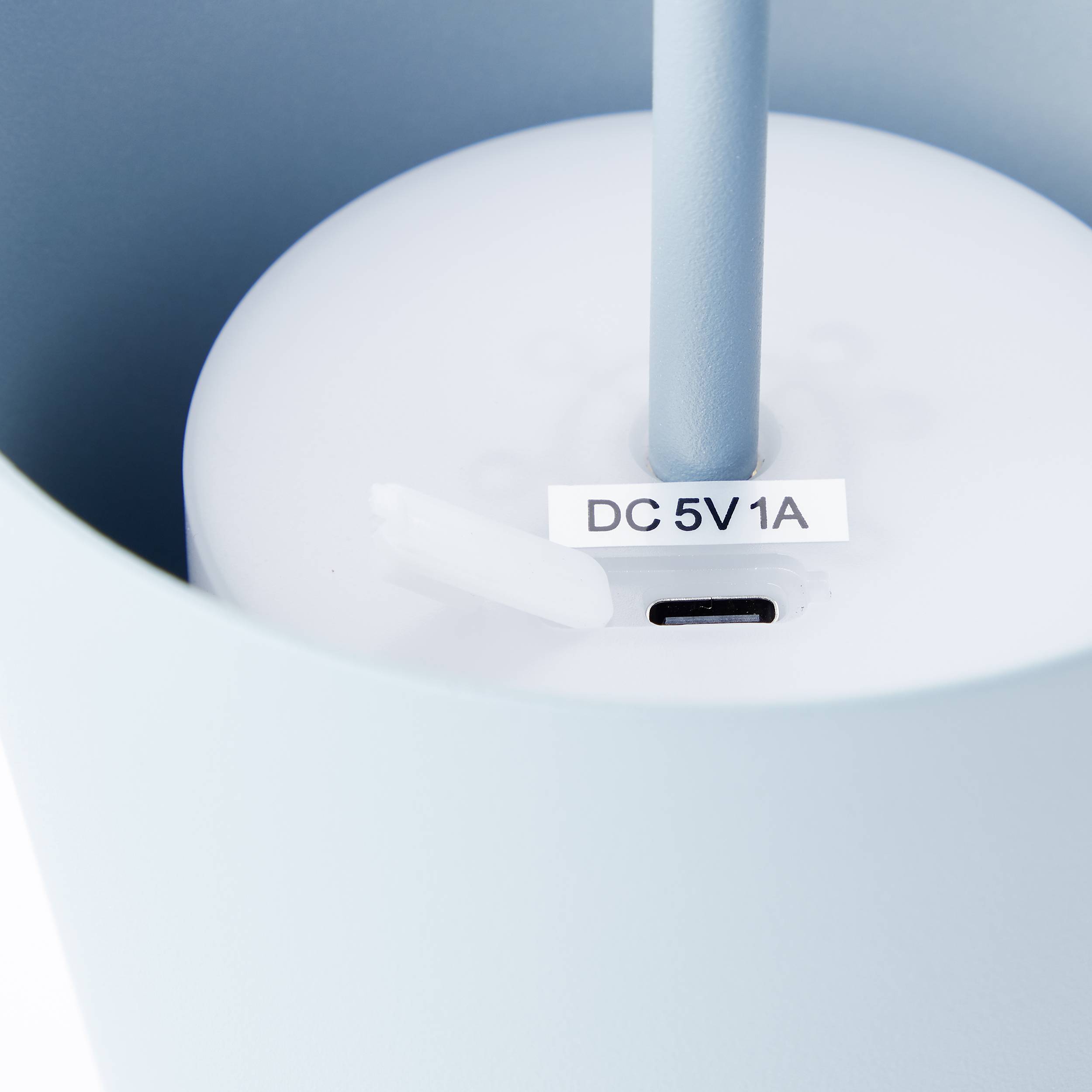 Gros plan d'un cylindre blanc portant une étiquette 'DC 5V 1A'.