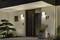 Façade moderne d'une maison avec une porte sombre, le numéro '27', des luminaires extérieurs carrés et un aménagement paysager minimaliste avec un bonsaï.