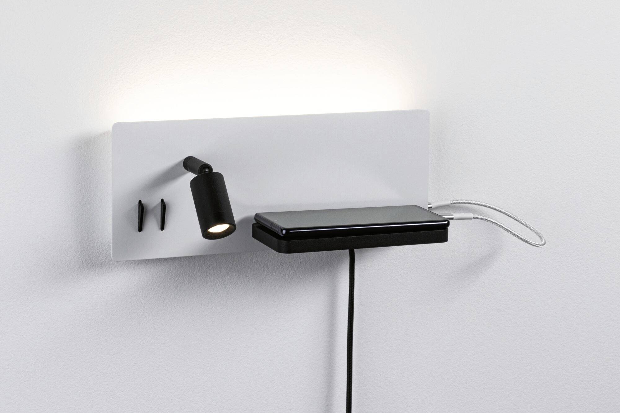 Un support mural rectangulaire blanc avec une petite lampe noire, deux crochets et une étagère sur laquelle repose un smartphone.