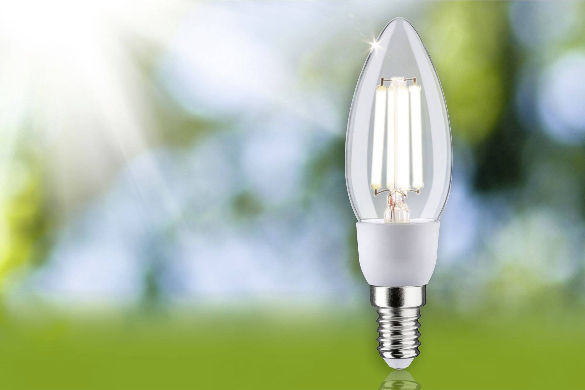 Une lampe LED brillante devant un arrière-plan flou et lumineux avec des rayons de soleil, symbolisant l'efficacité énergétique.