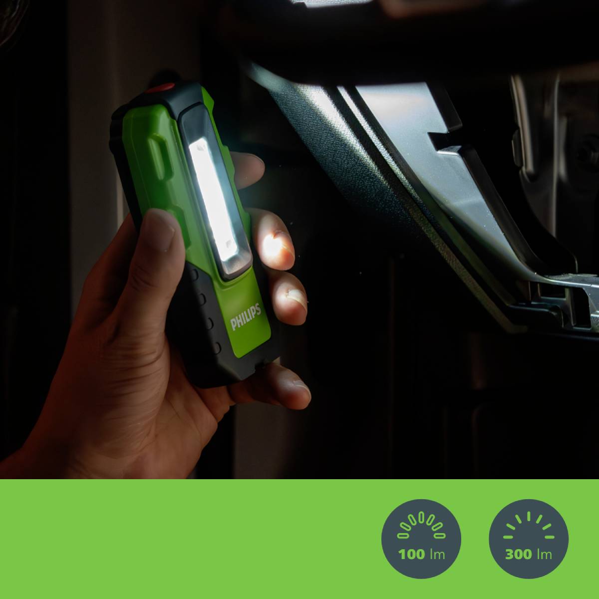 Une main tient une lampe LED verte et l'éclaire sur une surface sombre. En bas sont affichées des icônes indiquant la luminosité et la portée.