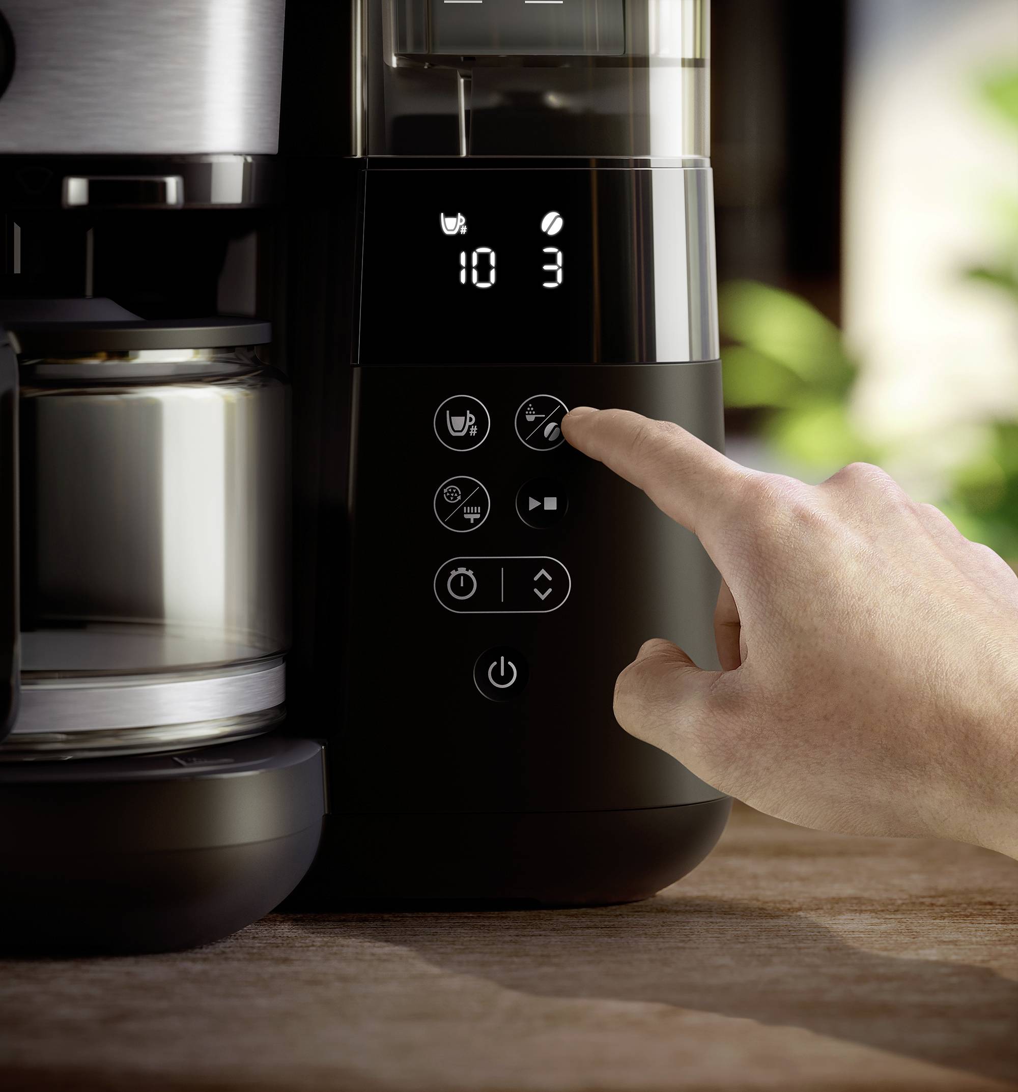 Une main effleure les touches d'un cafetier automatique moderne sur un plan de travail de cuisine. L'écran affiche '10:30'.