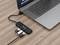 Un ordinateur portable est connecté via un hub USB à plusieurs périphériques USB, dont deux clés USB et un câble de charge.