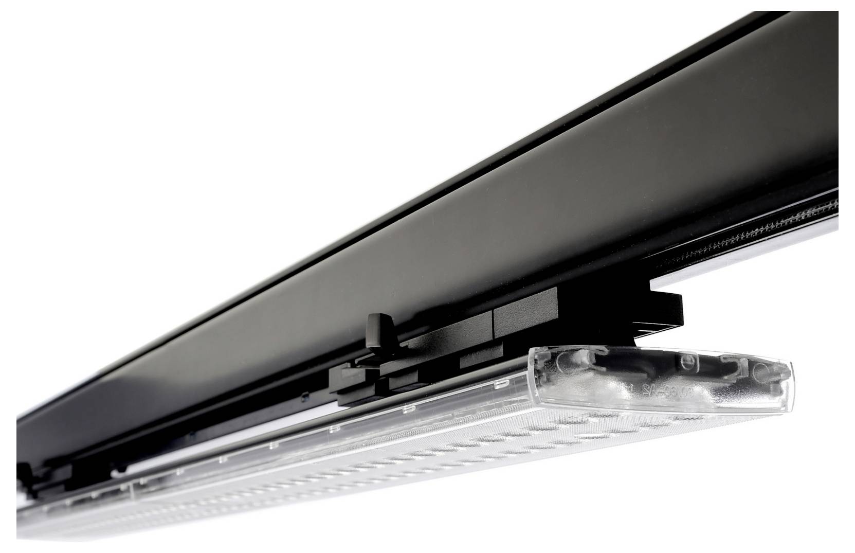 Gros plan d'un luminaire LED linéaire noir sur rail, sur fond blanc.