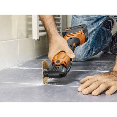 Une personne coupe un carrelage avec un outil oscillant. L'appareil présente un design noir et orange. L'accent est mis sur un travail précis.