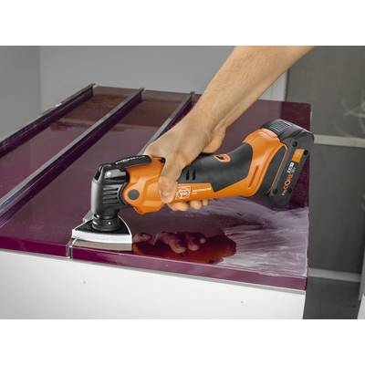 Une personne utilise un outil multifonction orange pour enlever de la peinture d'une surface.