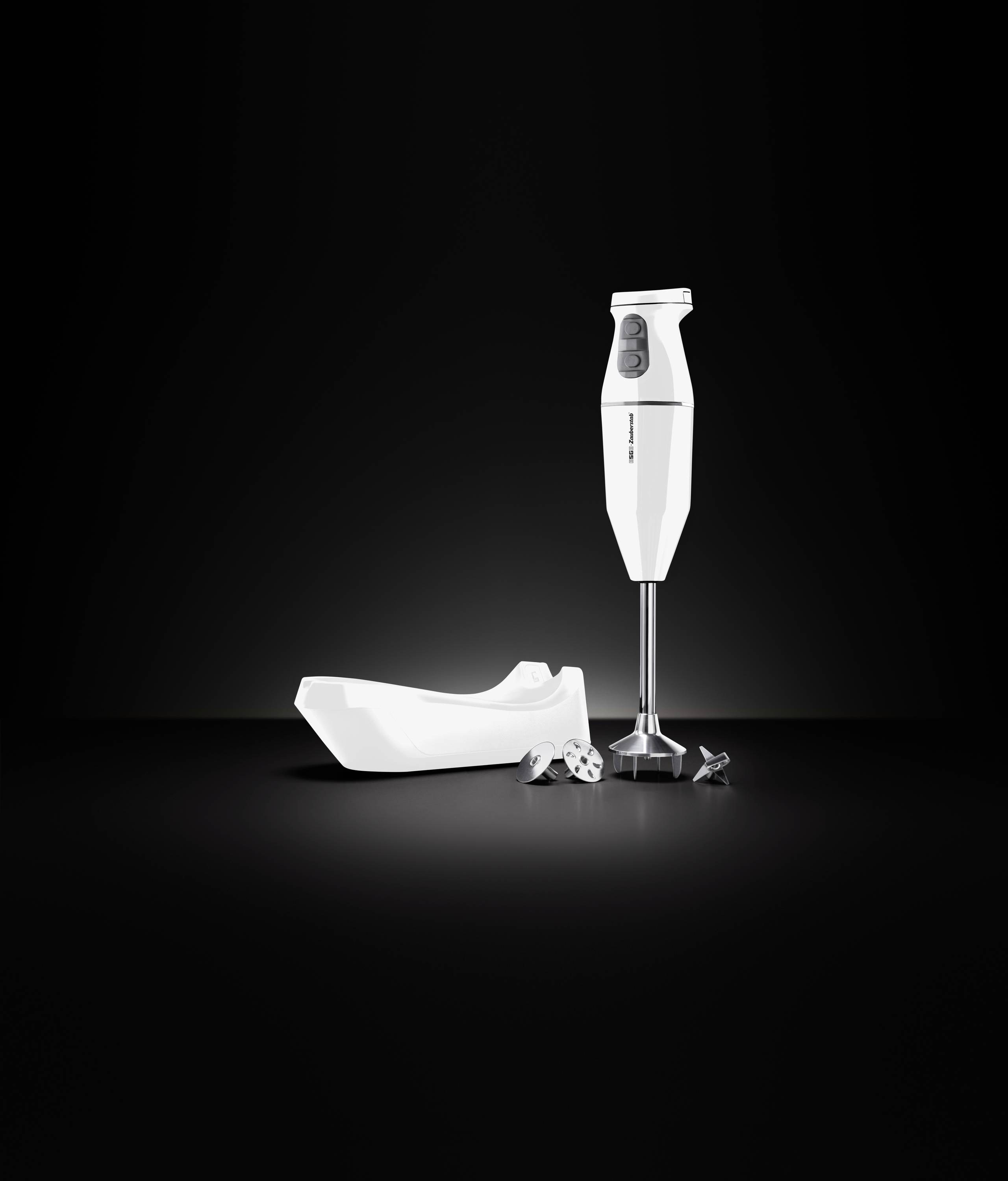 Un mixeur plongeant blanc avec plusieurs accessoires sur un fond noir, créé par Braun, représenté de profil avec des lames visibles.