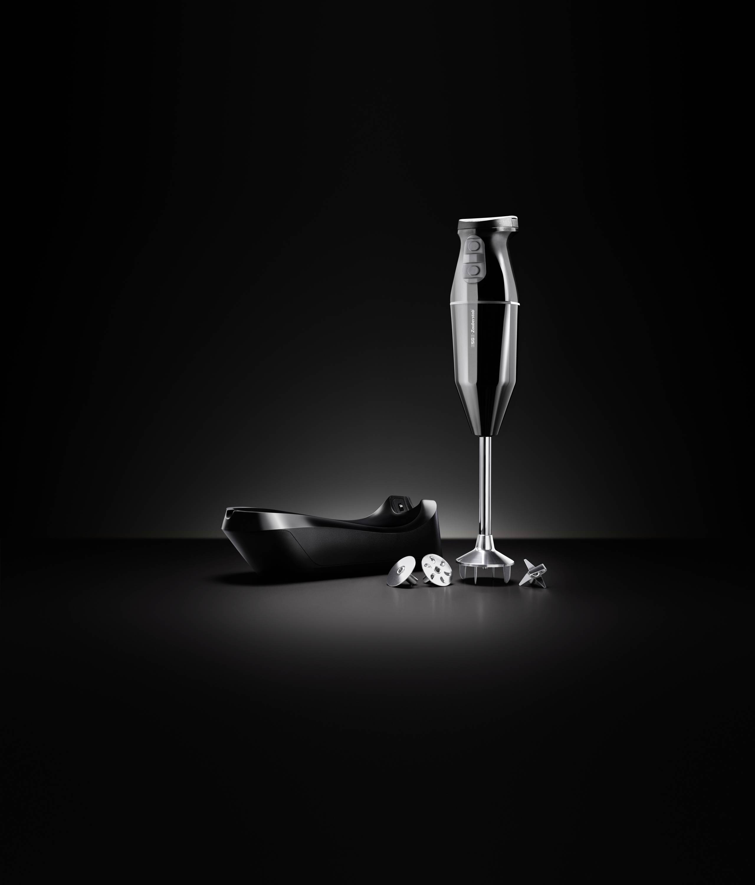 Mixeur noir avec accessoires sur fond sombre, comprenant un couvercle, des éléments de coupe et un socle; design moderne et élégant.