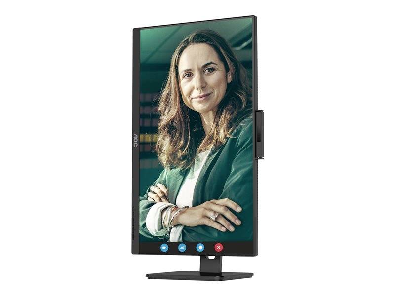 Une femme sur un écran d'ordinateur pivotant verticalement pendant un appel vidéo, sourit les bras croisés. Environnement de bureau en arrière-plan.