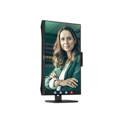 Un moniteur à affichage vertical montre une femme souriante portant un blazer vert. Des symboles d'options d'appel vidéo sont visibles en bas de l'écran.
