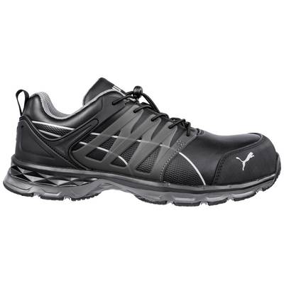 Une chaussure de sport noire avec des accents gris et un logo de marque reconnaissable sur le côté. La chaussure dispose d'une semelle robuste.