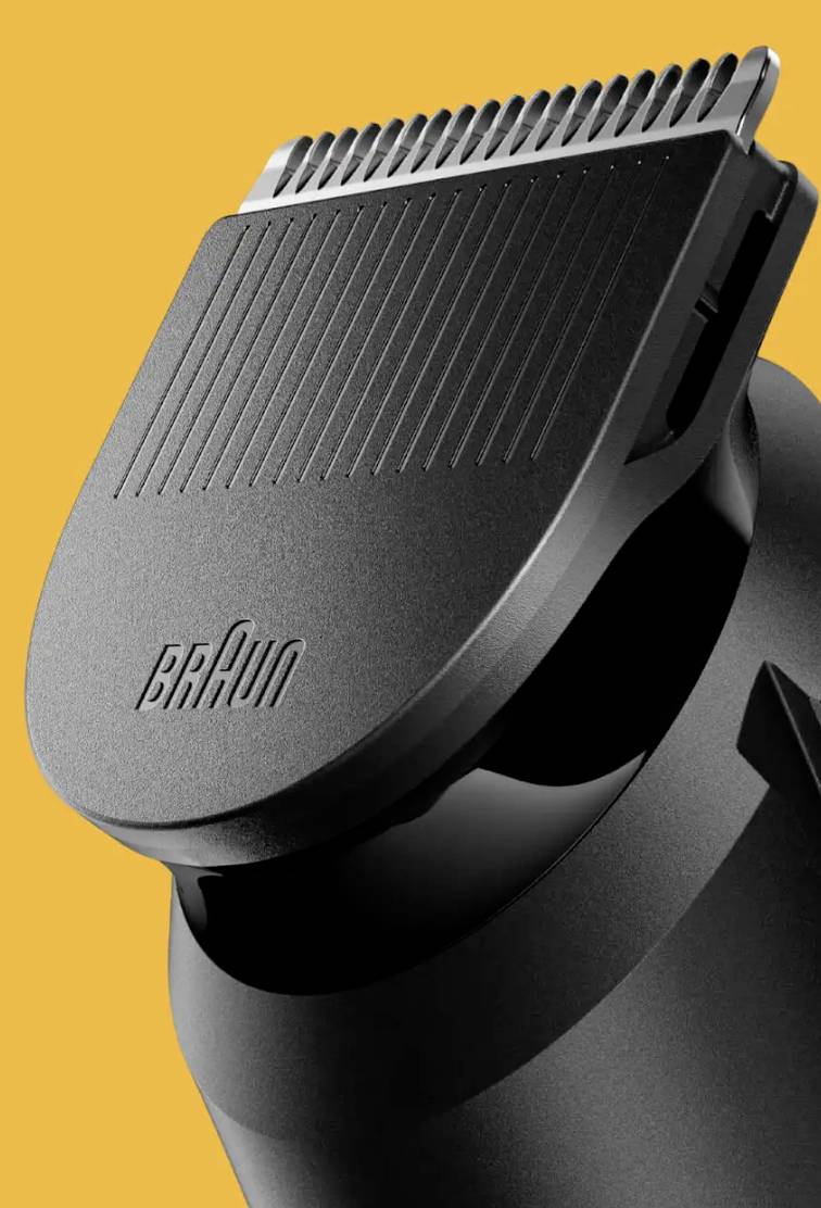 Gros plan d'un rasoir électrique noir de marque Braun avec un tondeuse, sur un fond orange.