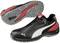 Deux chaussures de sport en cuir noir, avec des détails rouges et gris. Logo Puma sur le côté. Semelles profilées grises pour une meilleure adhérence.