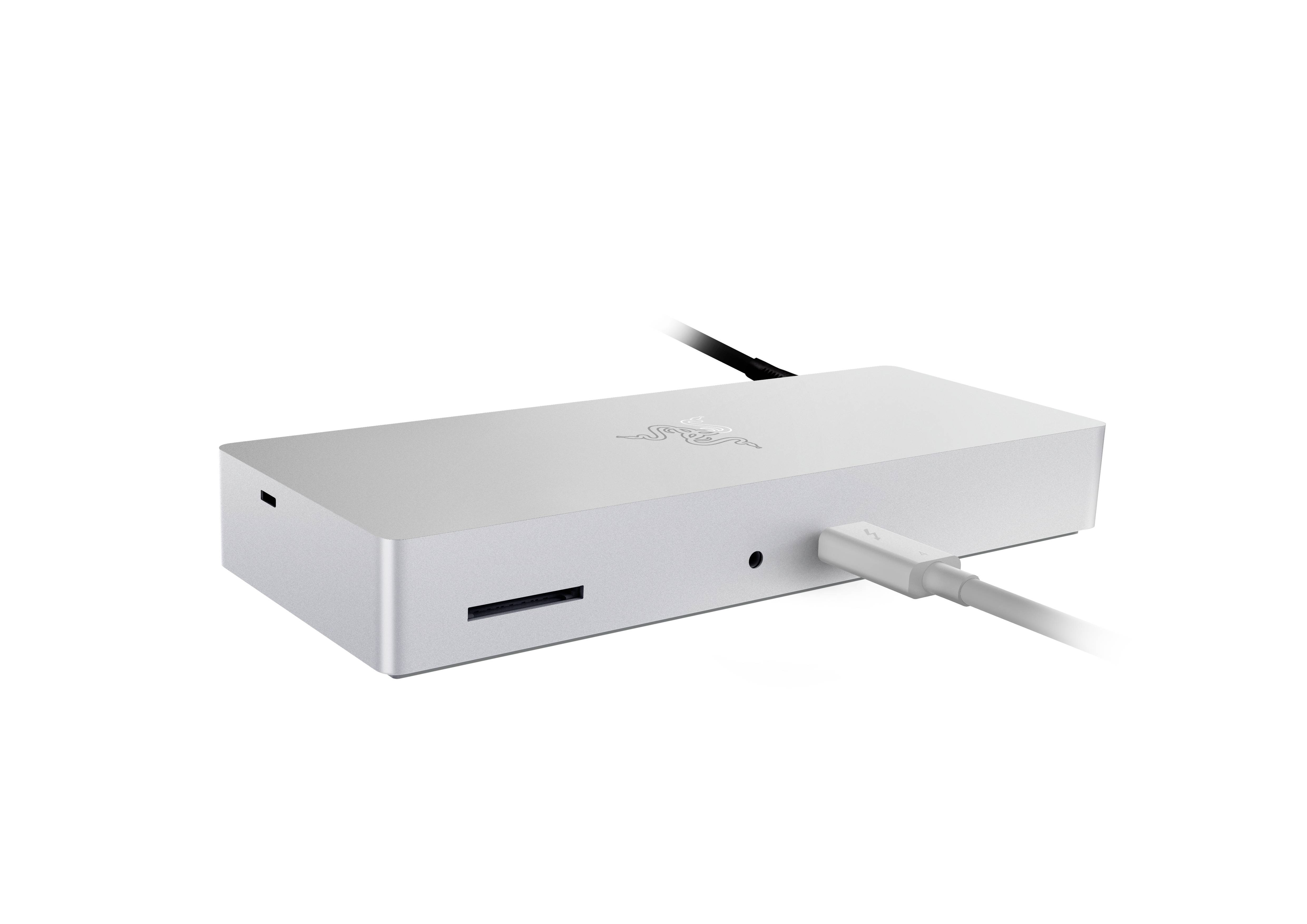 Une station d'accueil argentée avec plusieurs ports, dont un lecteur de carte SD et une prise audio, reliée par un câble.