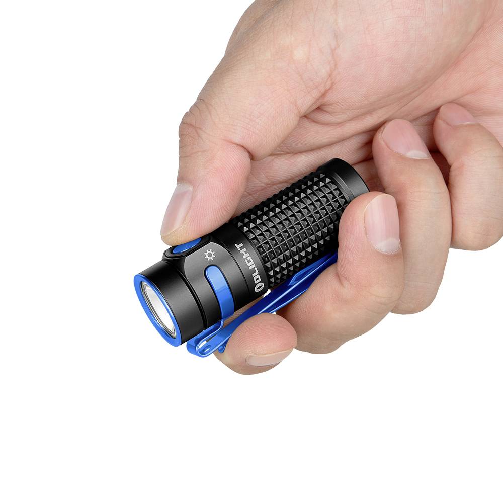 Une main tient une lampe de poche compacte.