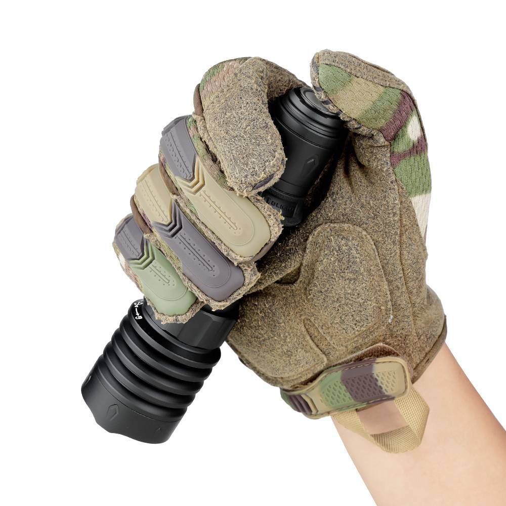 'Une main gantée de gants tactiques tient une lampe de poche noire.'