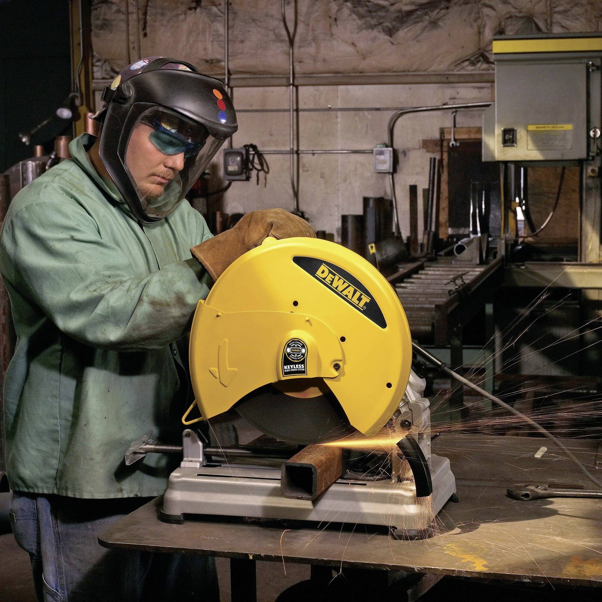 Un ouvrier en tenue de protection coupe du métal avec une scie circulaire jaune. Des étincelles volent pendant qu'il travaille avec concentration. Poste de travail en arrière-plan.