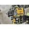 Une personne tient un tournevis sans fil jaune de la marque Dewalt avec une poignée noire, prêt à être utilisé.