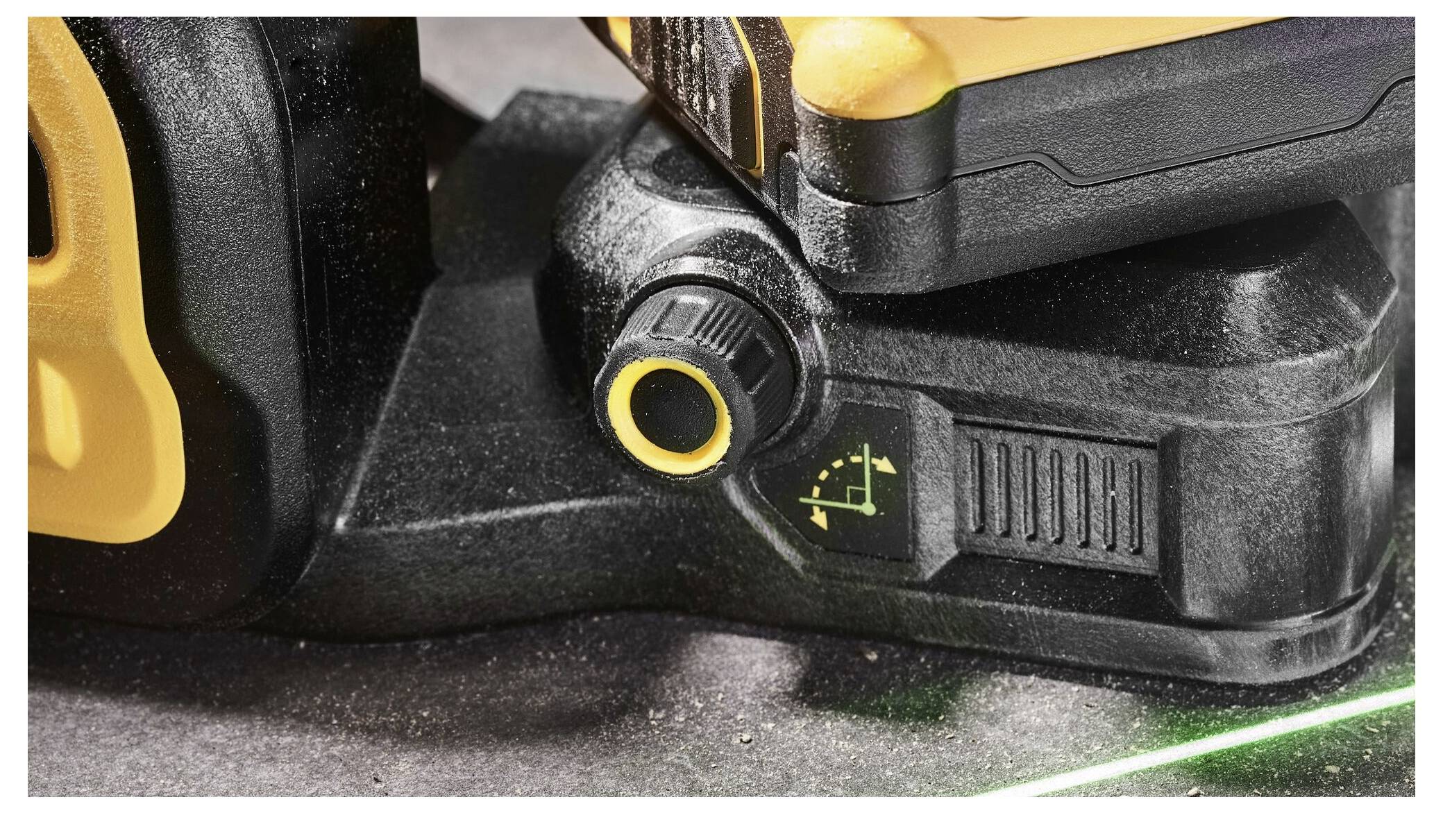 Un outil électronique doté d'un bouton de réglage et d'un faisceau laser vert sur une surface, probablement utilisé pour l'alignement.